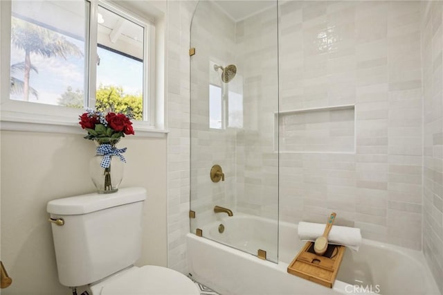 bathroom featuring tiled shower / bath combo and toilet