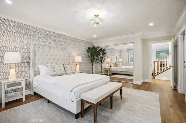 bedroom featuring hardwood / wood-style floors, ornamental molding, and a closet