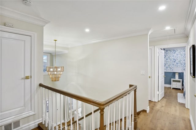 hallway with light hardwood / wood-style flooring and ornamental molding