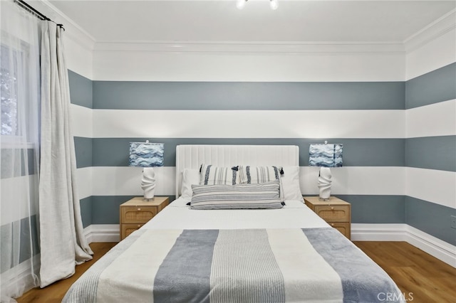 bedroom featuring wood-type flooring and ornamental molding