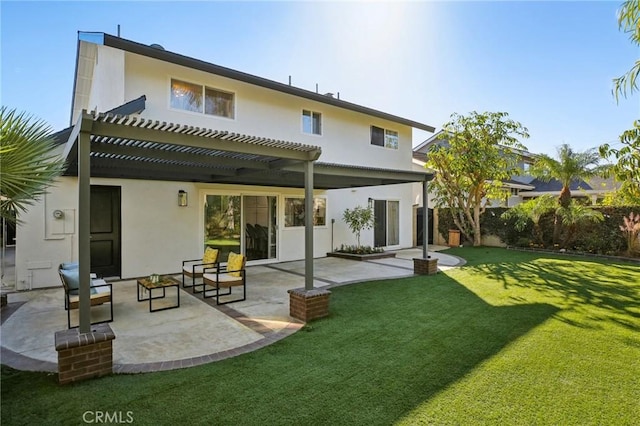 rear view of property featuring a yard, a pergola, and a patio area