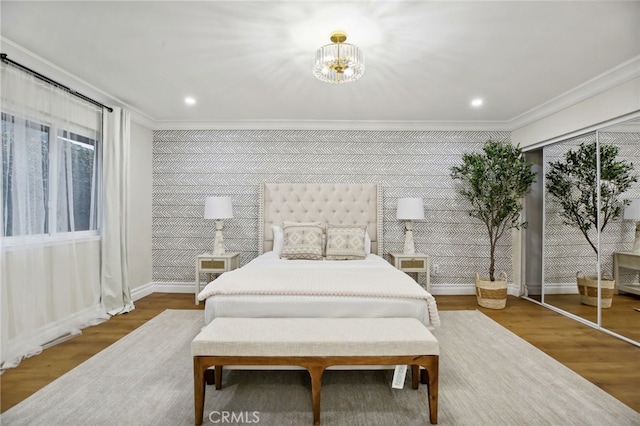 bedroom featuring ornamental molding, a notable chandelier, and hardwood / wood-style flooring