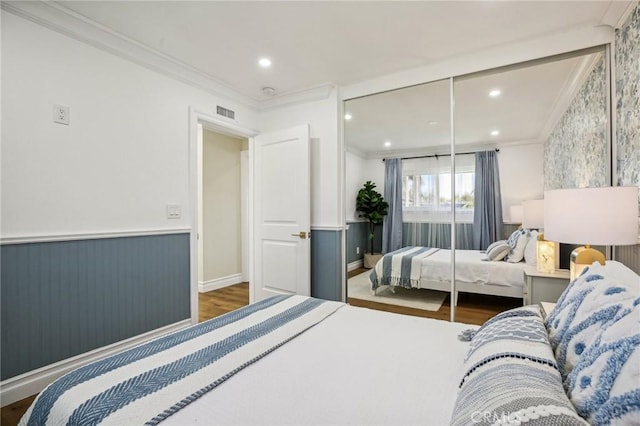 bedroom featuring dark hardwood / wood-style flooring, a closet, and ornamental molding