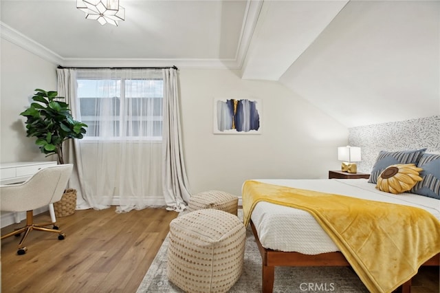 bedroom featuring hardwood / wood-style flooring, lofted ceiling, and crown molding