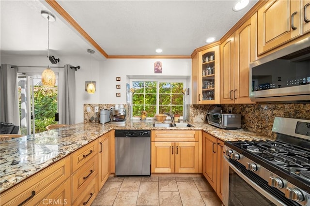 kitchen featuring light stone counters, sink, kitchen peninsula, and stainless steel appliances