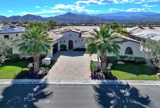 mediterranean / spanish house featuring a mountain view and a front lawn