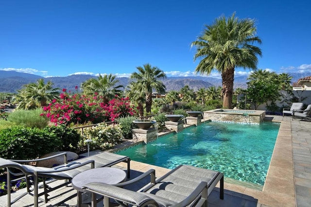 view of swimming pool with an in ground hot tub, a mountain view, pool water feature, and a patio area