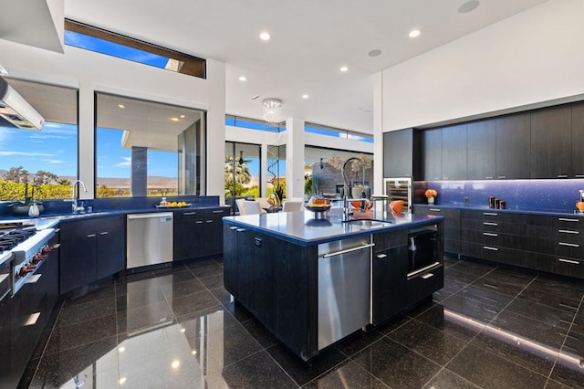 kitchen featuring a center island with sink, dishwasher, backsplash, and sink