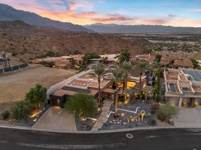 aerial view at dusk featuring a mountain view