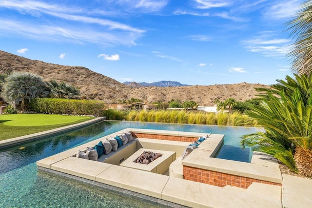 view of swimming pool featuring a mountain view and an outdoor fire pit