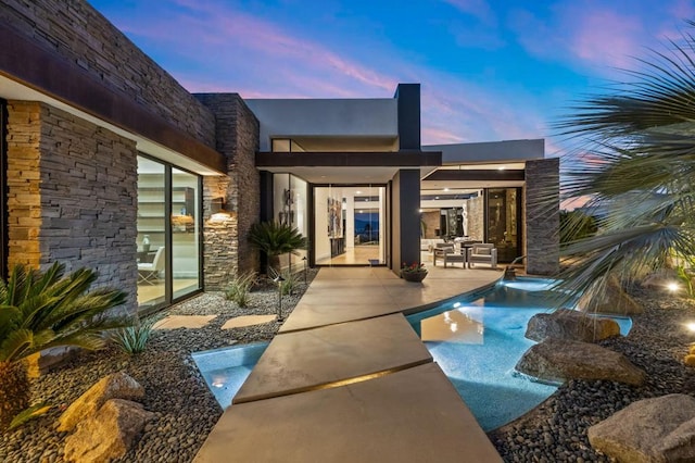 back house at dusk with a patio