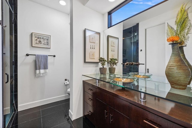 bathroom featuring tile patterned floors, vanity, toilet, and walk in shower