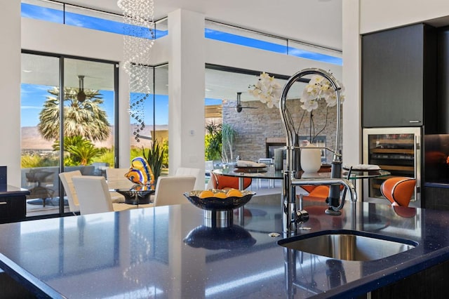 kitchen featuring a chandelier, sink, beverage cooler, and a healthy amount of sunlight