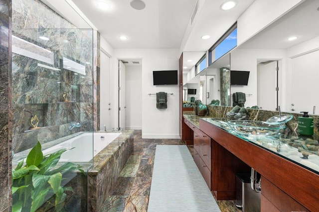 bathroom featuring vanity and tiled tub