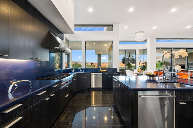 kitchen featuring appliances with stainless steel finishes, tasteful backsplash, wall chimney exhaust hood, and sink