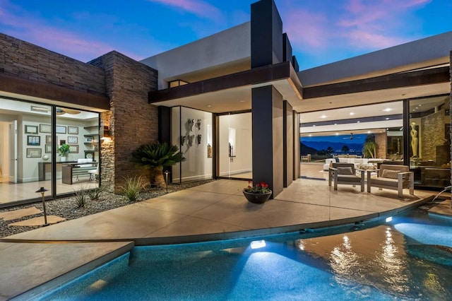 pool at dusk featuring a patio