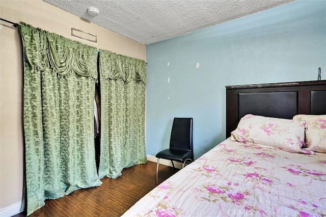 bedroom with dark hardwood / wood-style flooring and a textured ceiling