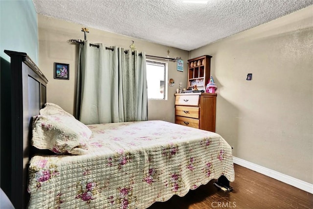 bedroom featuring a textured ceiling and dark hardwood / wood-style flooring