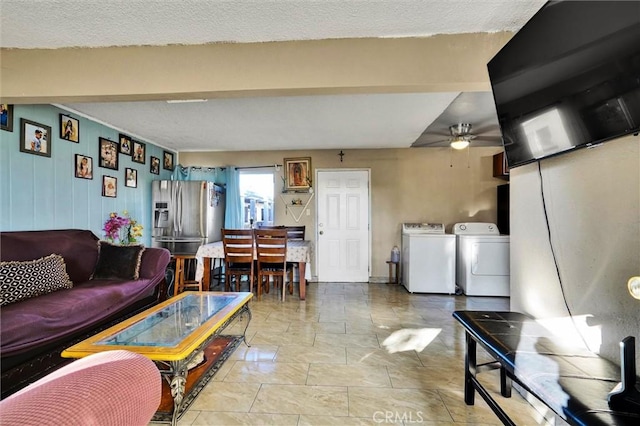 living room featuring washing machine and clothes dryer, ceiling fan, and a textured ceiling