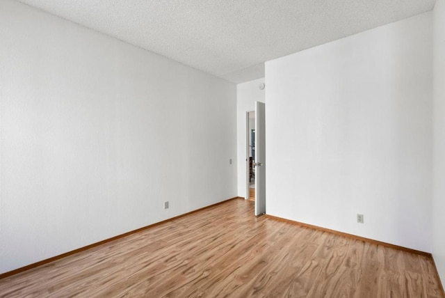 empty room featuring light hardwood / wood-style floors and a textured ceiling