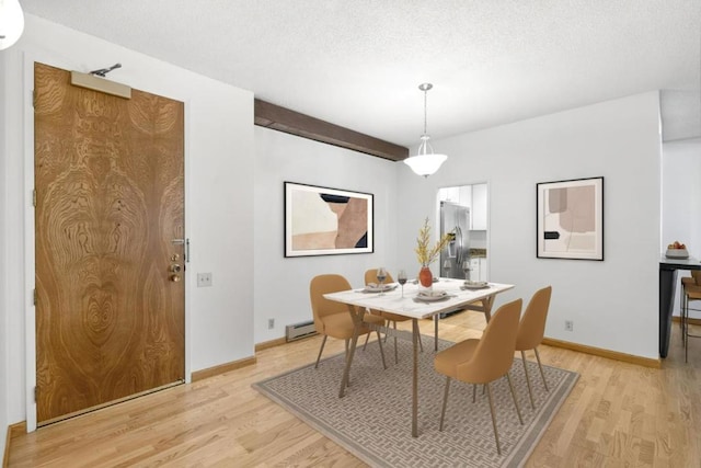 dining area with a textured ceiling, light hardwood / wood-style floors, and baseboard heating