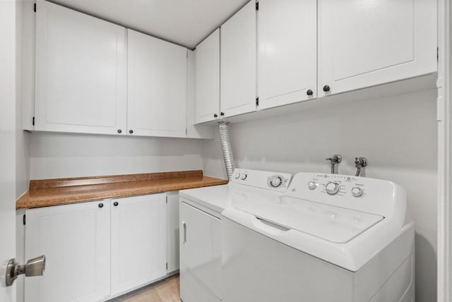 laundry area with cabinets, light tile patterned floors, and separate washer and dryer