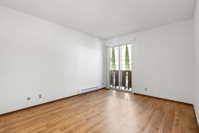 unfurnished room featuring light hardwood / wood-style flooring and a baseboard heating unit