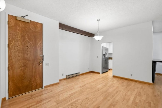 interior space with beam ceiling, a textured ceiling, light hardwood / wood-style flooring, and baseboard heating