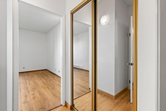 corridor featuring hardwood / wood-style floors and baseboard heating