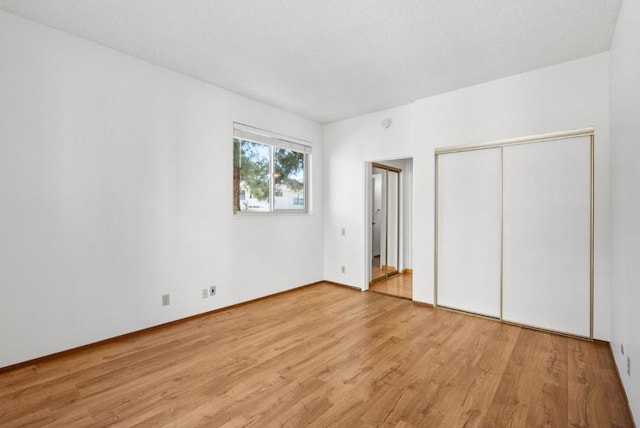 unfurnished bedroom featuring light wood-type flooring and a closet