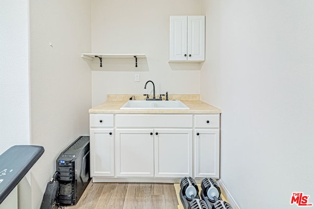 kitchen featuring light hardwood / wood-style flooring, white cabinets, and sink