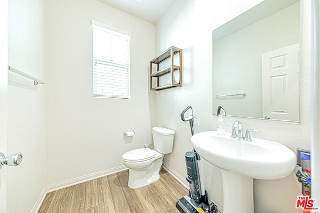 bathroom with toilet, sink, and hardwood / wood-style floors