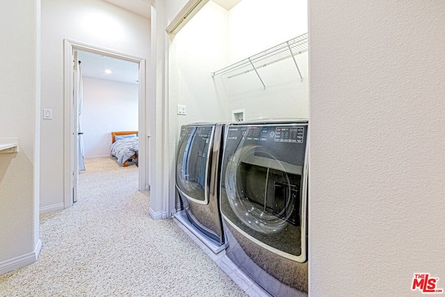 clothes washing area with carpet floors and washing machine and clothes dryer