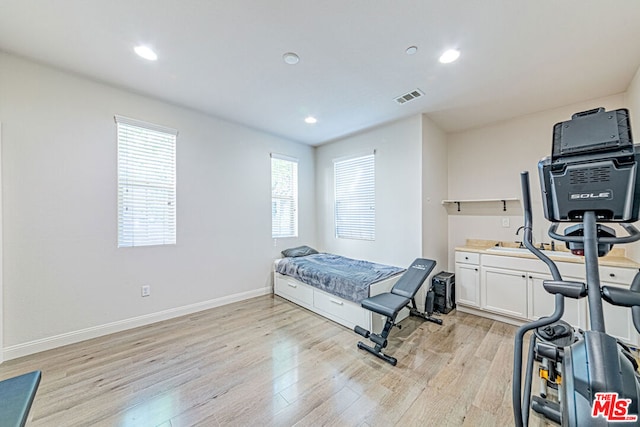 bedroom with light wood-type flooring and multiple windows