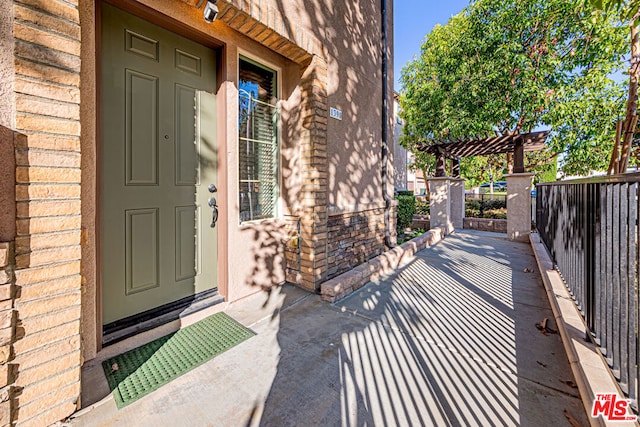 doorway to property with a pergola