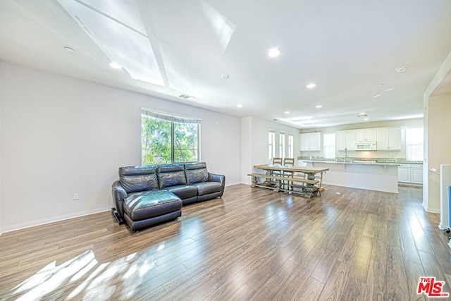 living room featuring sink and light hardwood / wood-style flooring