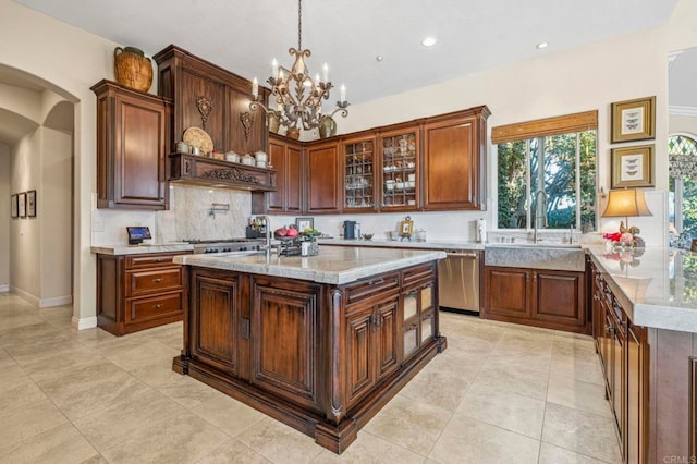 kitchen with a center island with sink, sink, hanging light fixtures, stainless steel dishwasher, and a notable chandelier