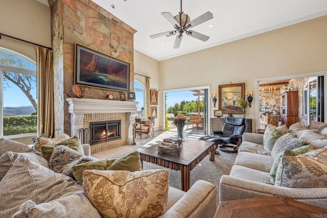 living room featuring a wealth of natural light, a fireplace, and a towering ceiling