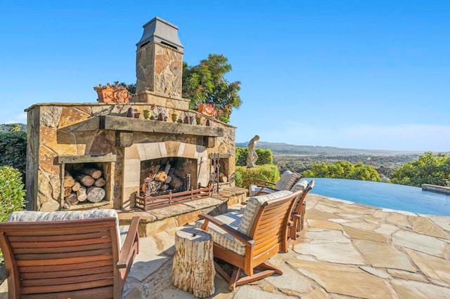 view of patio featuring an outdoor stone fireplace