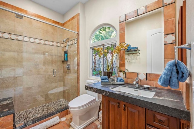 bathroom featuring tile patterned floors, toilet, vanity, and walk in shower