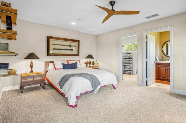 bedroom featuring light carpet, connected bathroom, and ceiling fan