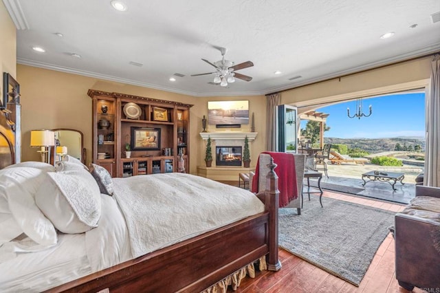 bedroom featuring ceiling fan with notable chandelier, access to exterior, wood-type flooring, and ornamental molding