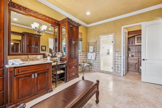 bathroom with tile patterned floors, crown molding, vanity, and a notable chandelier