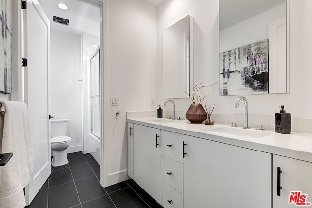 full bathroom featuring combined bath / shower with glass door, vanity, tile patterned floors, and toilet