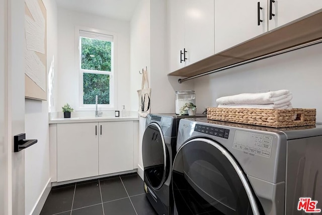 laundry room featuring washer and clothes dryer, sink, dark tile patterned floors, and cabinets