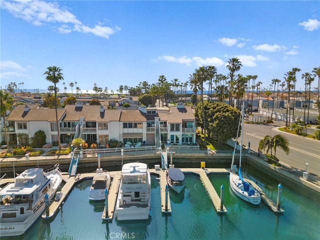 view of dock featuring a water view, boat lift, and a residential view