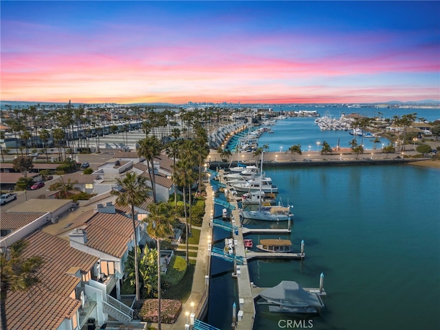 aerial view at dusk featuring a water view