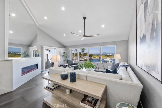 living room featuring ceiling fan, lofted ceiling, and a healthy amount of sunlight