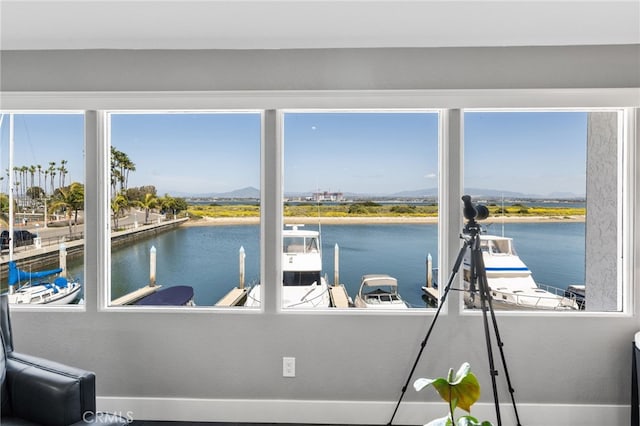 sunroom / solarium featuring a water view