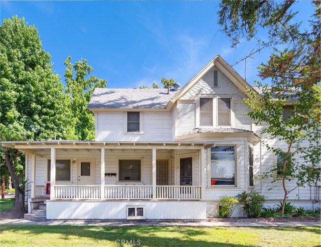 victorian house with a porch and a front lawn